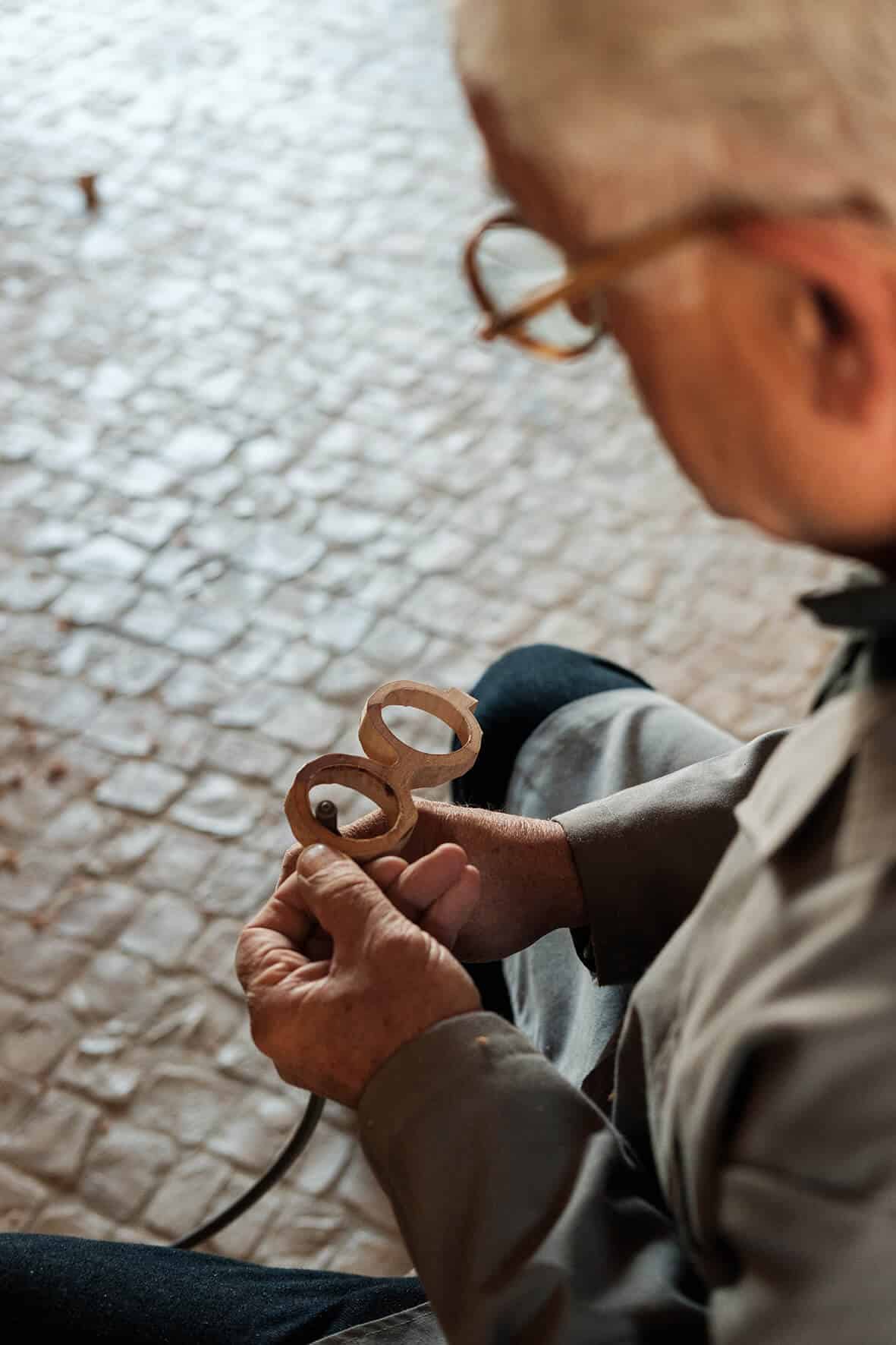 Amâncio Neves trabalha num par de óculos de madeira.
