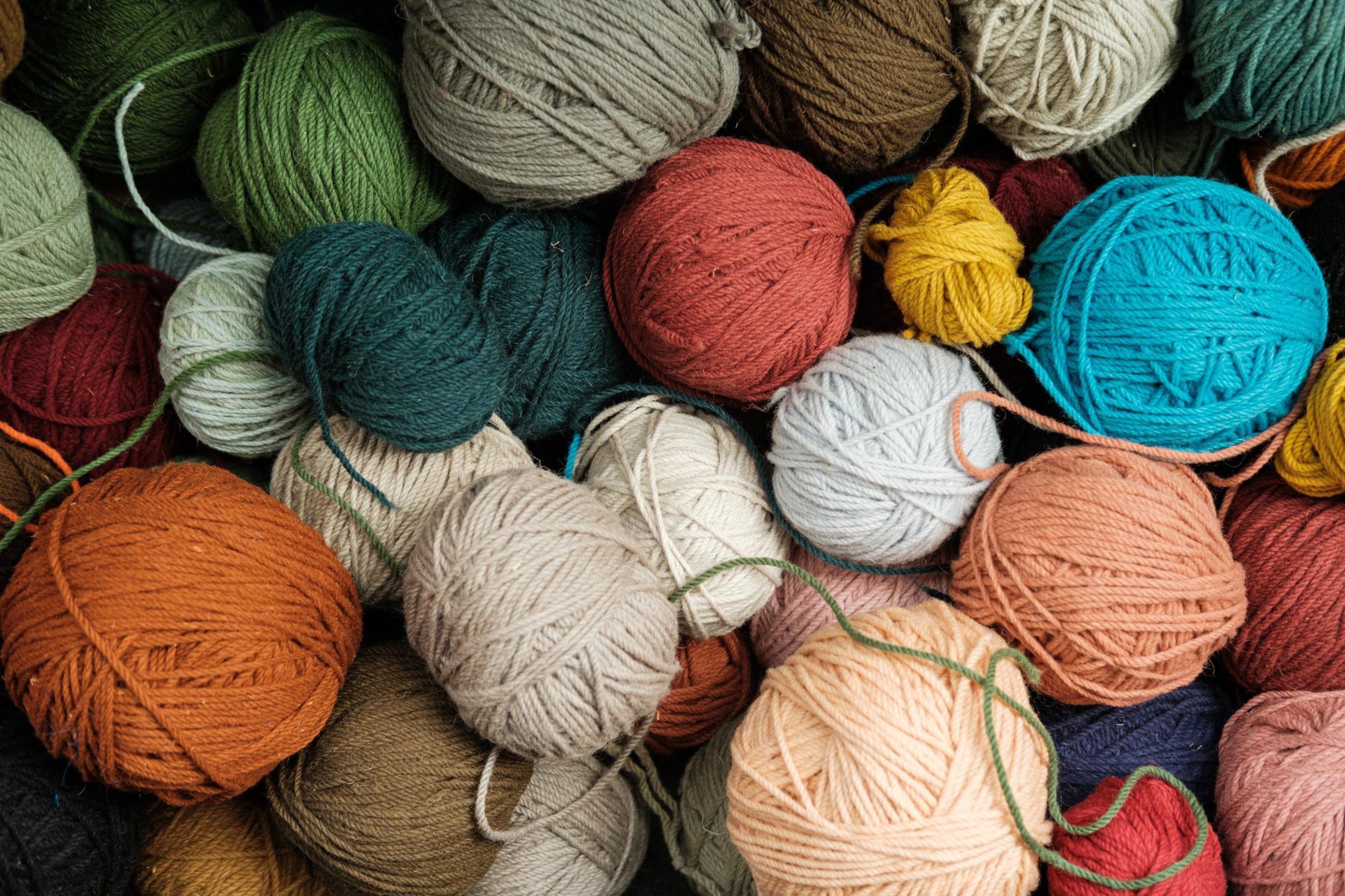 Fios de lã coloridos de vários tamanhos e cores agrupados.