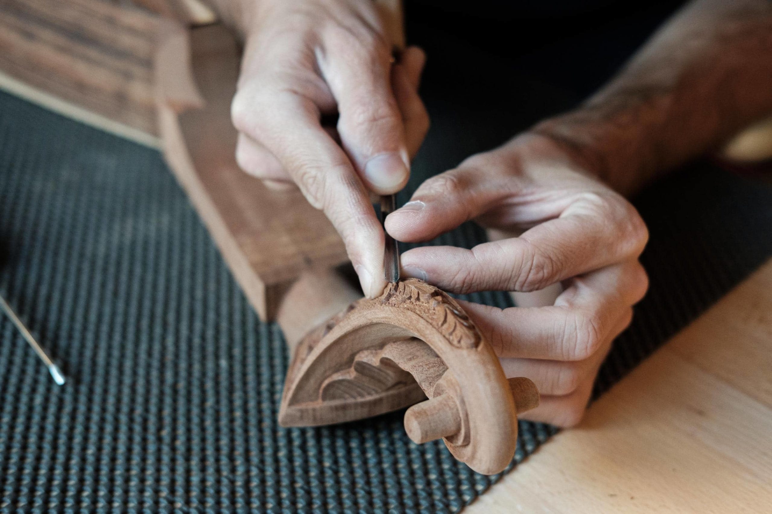 Mãos do artista Leonardo Afonso afinam detalhes na cabeça da guitarra.