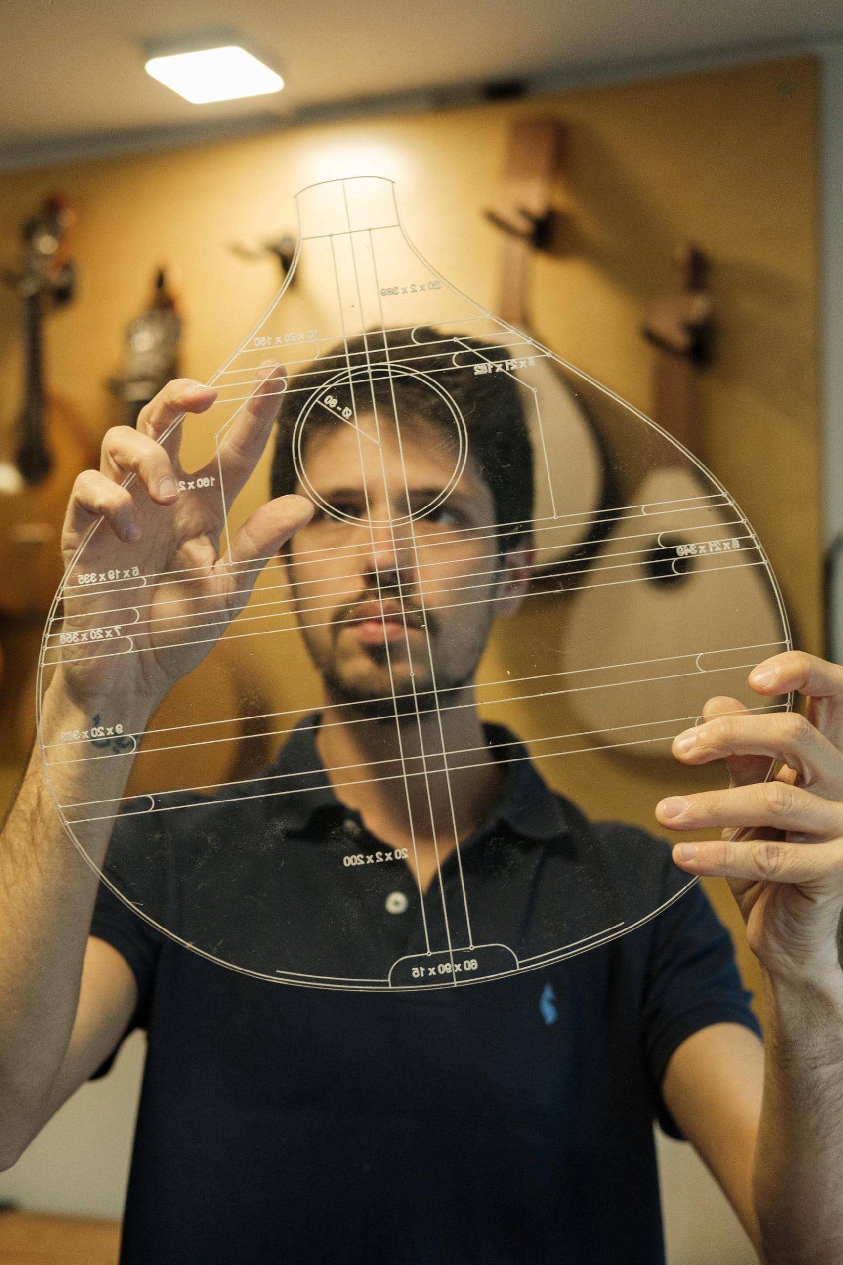 Artista Leonardo Afonso confere detalhes e medidas da guitarra em molde transparente.