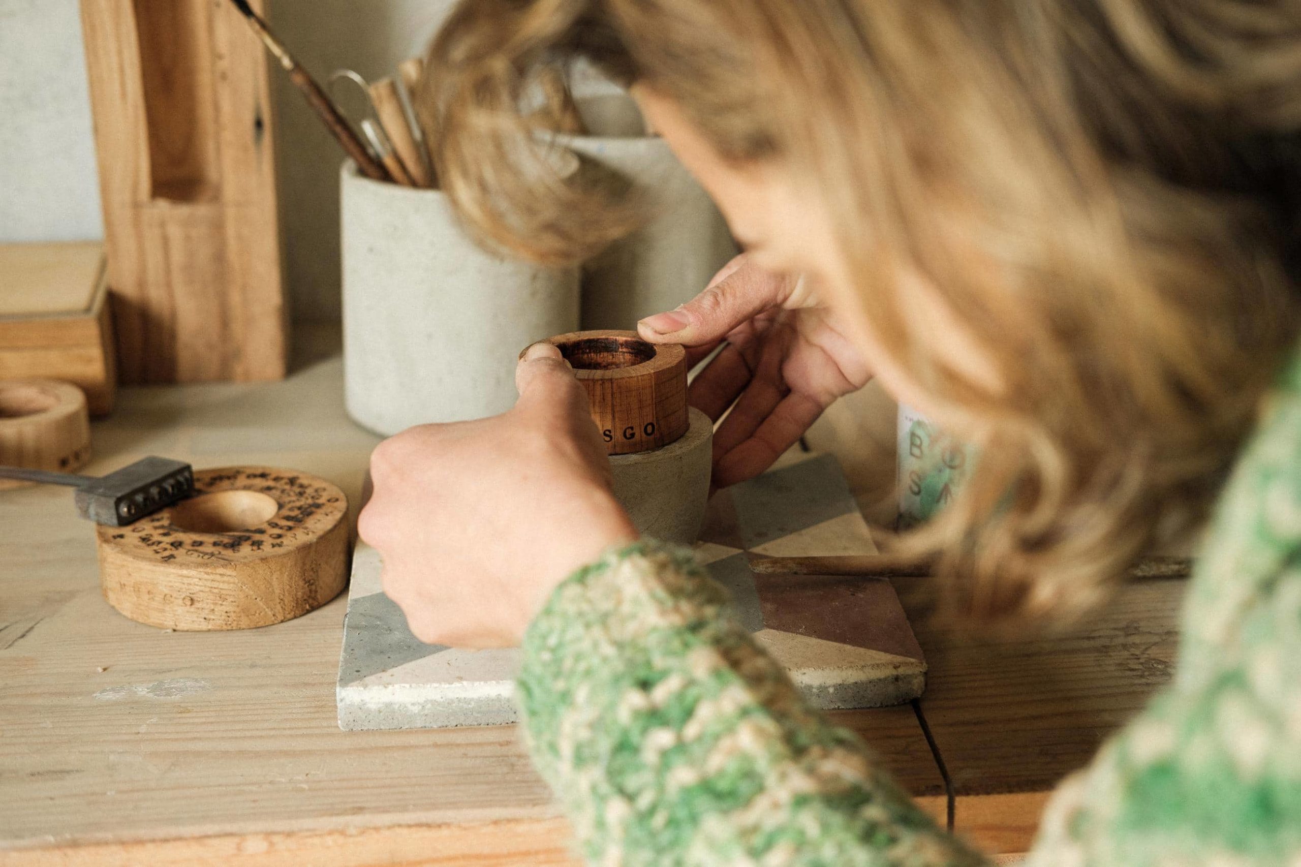 Margarida encaixa partes de madeira em base de cimento de uma das peças Musgo.